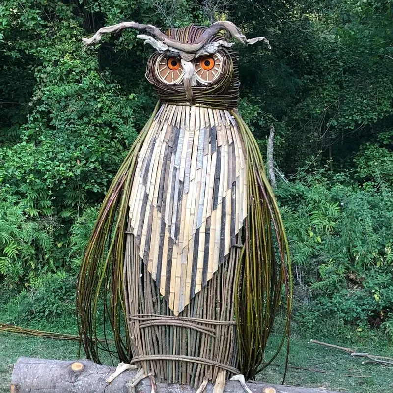 La scultura di un gufo in legno tra i prati dell'Appennino bolognese